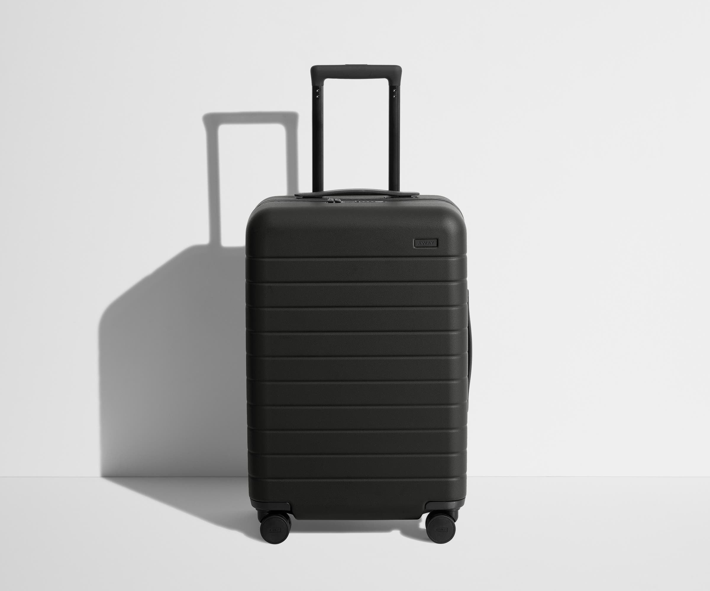 Away The Bigger Carry-On hardside suitcase in Jet Black, front view with the trolley handle raised