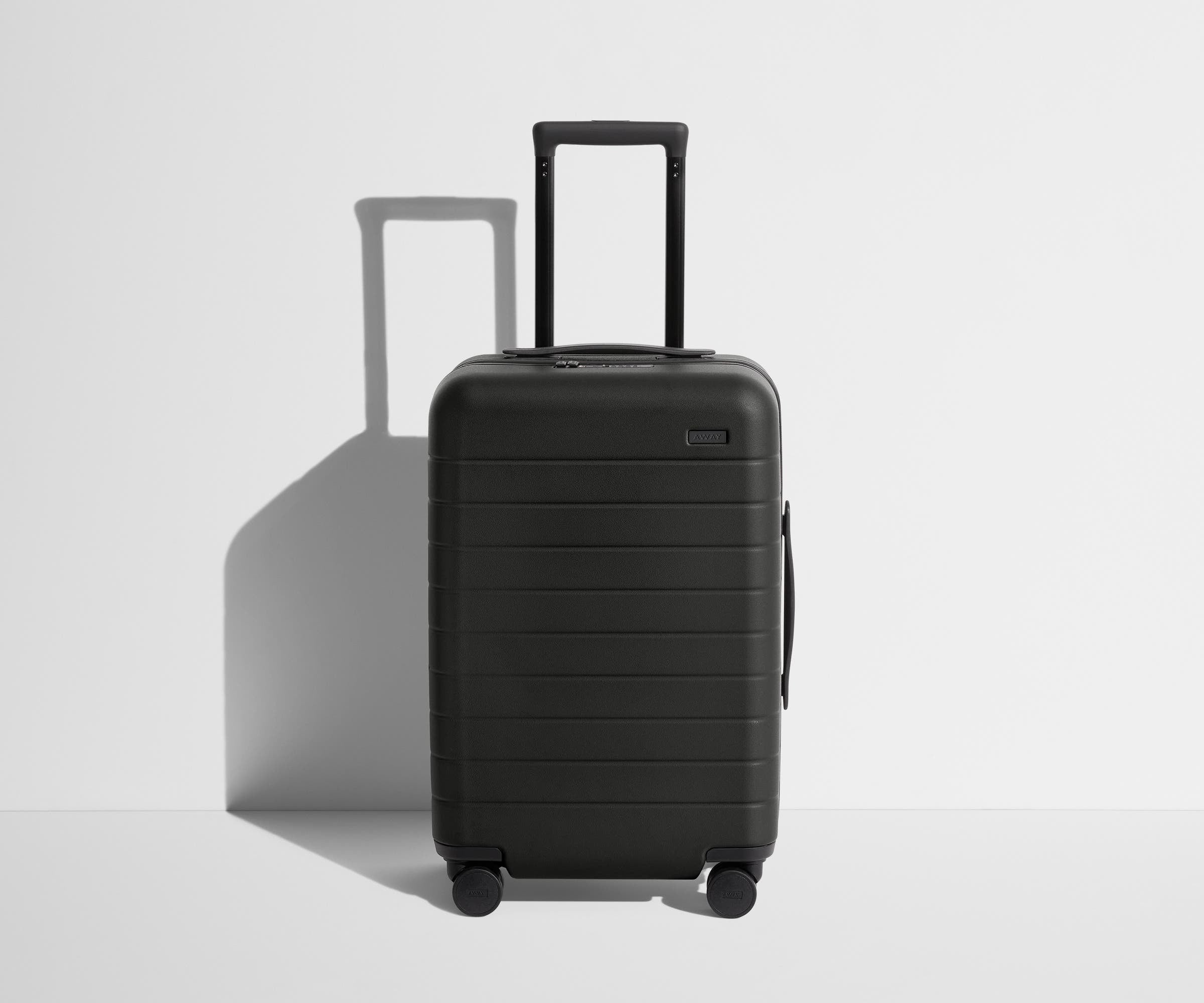 Away The Carry-On hardside suitcase in Jet Black, front view with the trolley handle raised