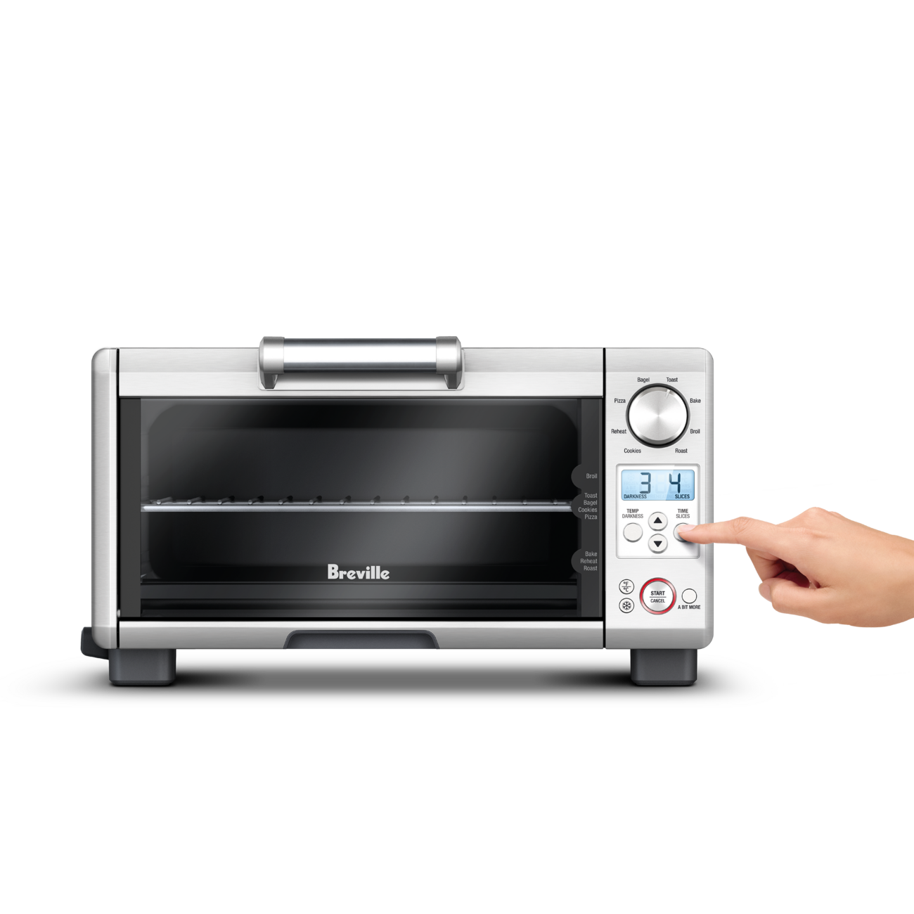Brushed stainless steel Breville the Mini Smart Oven BOV450 countertop oven with its door closed, a hand pressing a button on the control panel