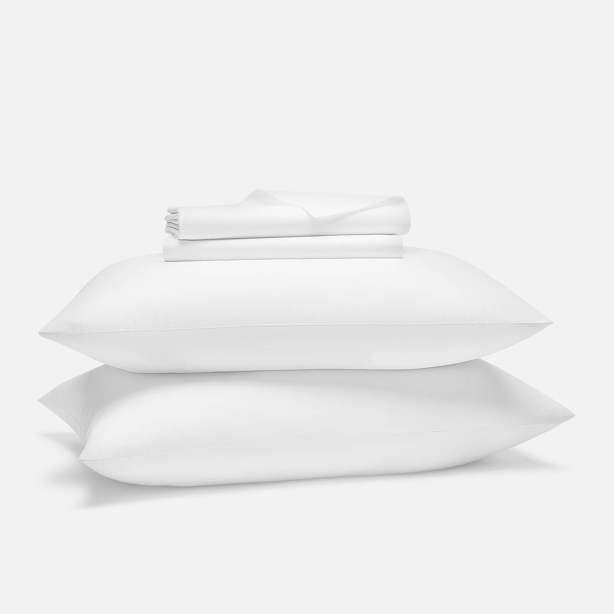 Folded white Brooklinen Classic Percale sheet set with the flat sheet, fitted sheet and two pillowcases stacked