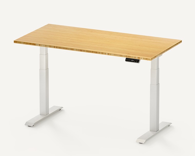 White FlexiSpot E7 standing desk frame under a bamboo desktop, seen at an angle