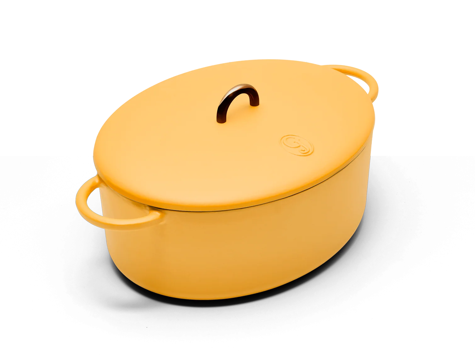 Great Jones The Dutchess 6.75-quart oval enameled cast iron Dutch oven in Mustard, shown whole with its lid, a dark brown lid knob and two side loop handles, on a transparent background