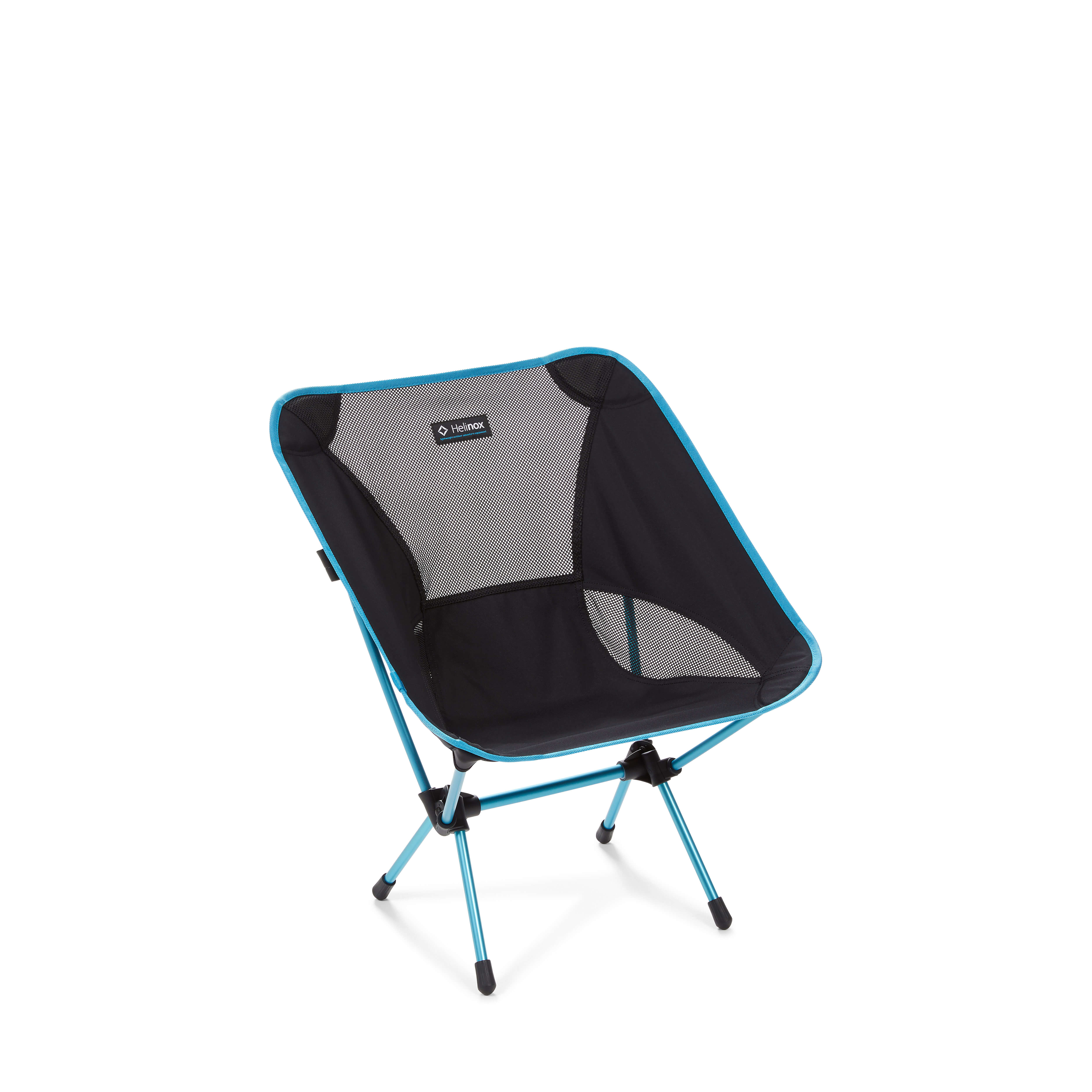 Helinox Chair One assembled on a plain white background, seen from a three-quarter angle: black fabric seat with black mesh back and side panels, a woven Helinox label at the top of the seatback, and cyan anodized aluminum legs crossing through black hubs, with black rubber feet on the ground