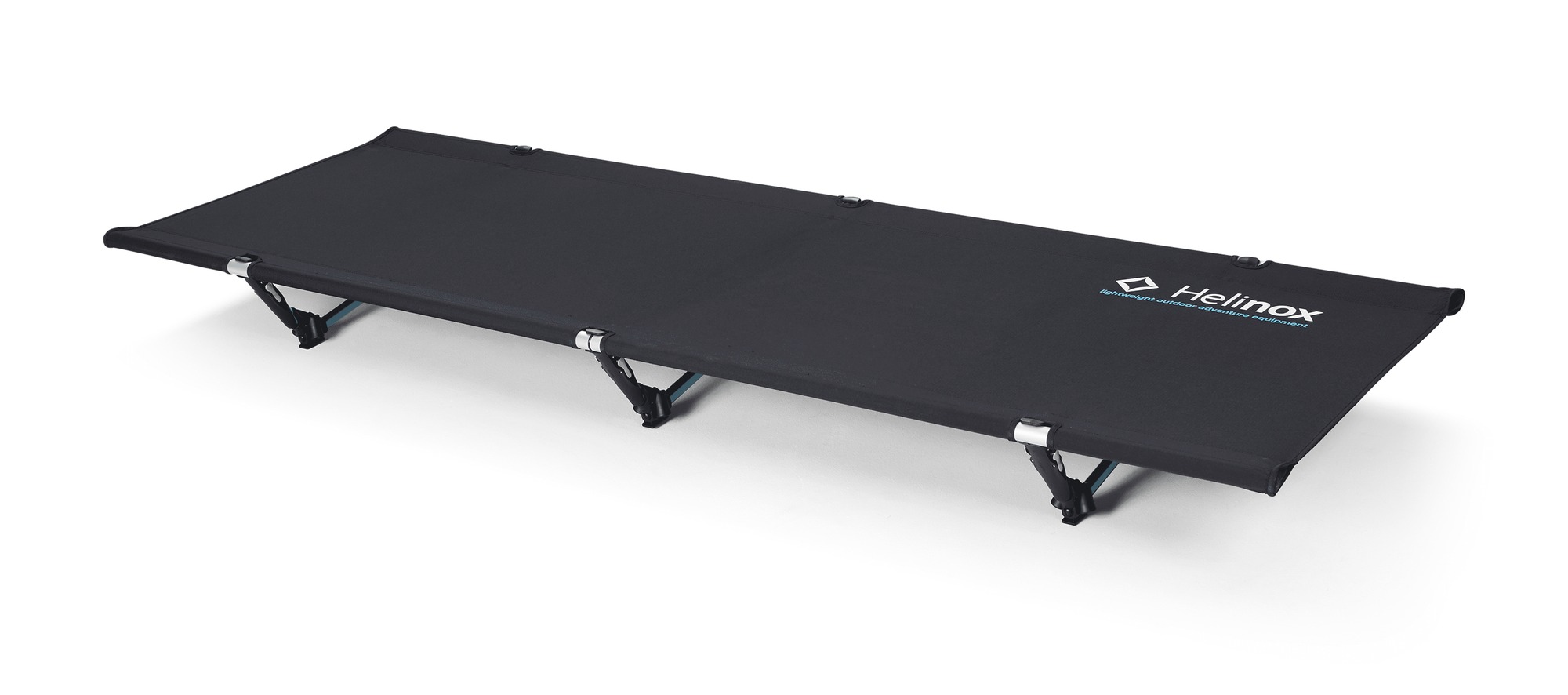 Helinox Cot One Convertible in Black, fully assembled, photographed from a low three-quarter angle on a plain white background: a taut black rectangular deck with a white Helinox wordmark and a smaller cyan tagline line printed near the right end, three black leg assemblies with silver-colored joints spaced along the near edge, small dark tabs on the deck edge, and a soft shadow under the frame