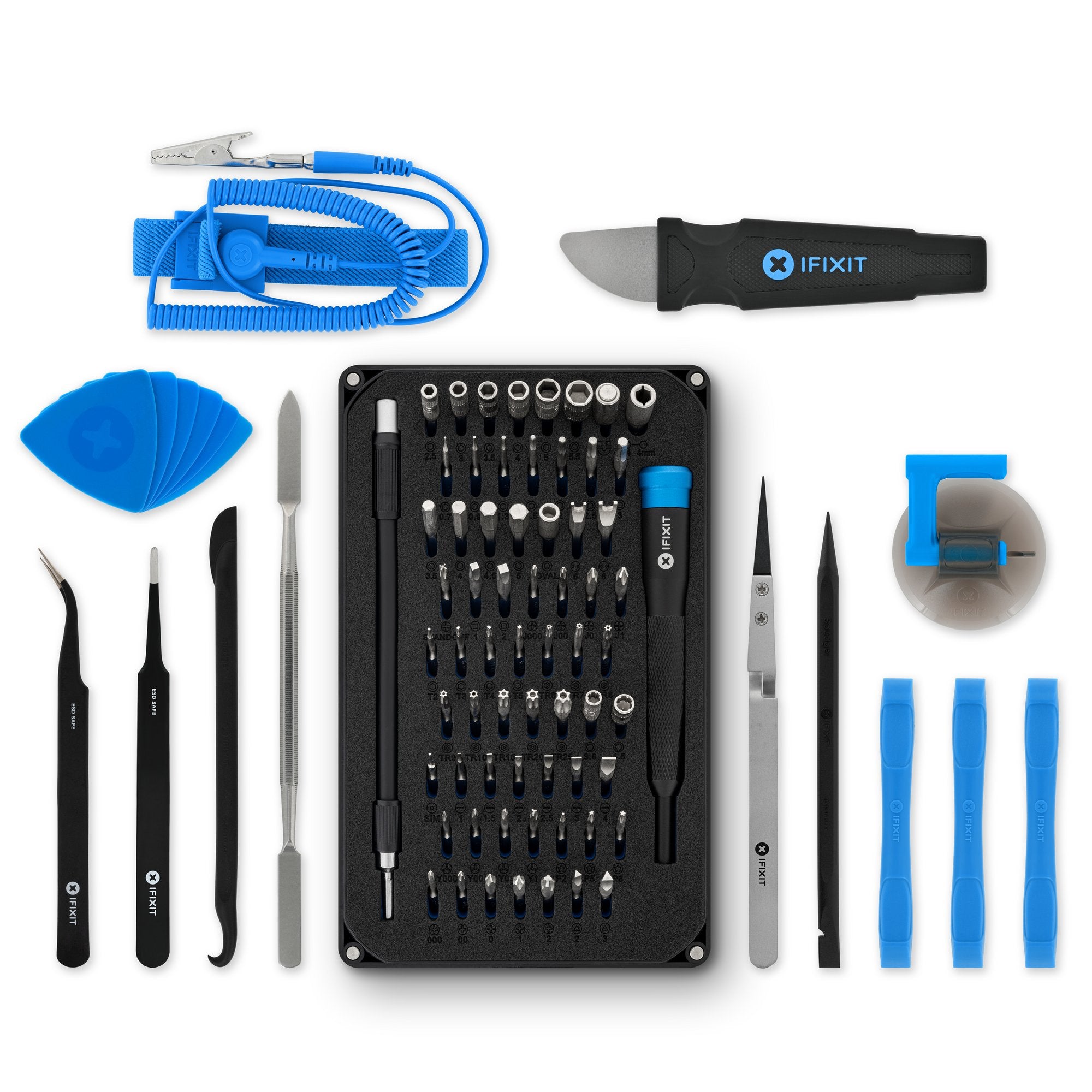 iFixit Pro Tech Toolkit tools laid out on a white background: the driver handle, the 64-bit set in its black tray, ESD tweezers, black spudgers, blue opening picks, a metal spatula, a suction handle and a blue anti-static wrist strap