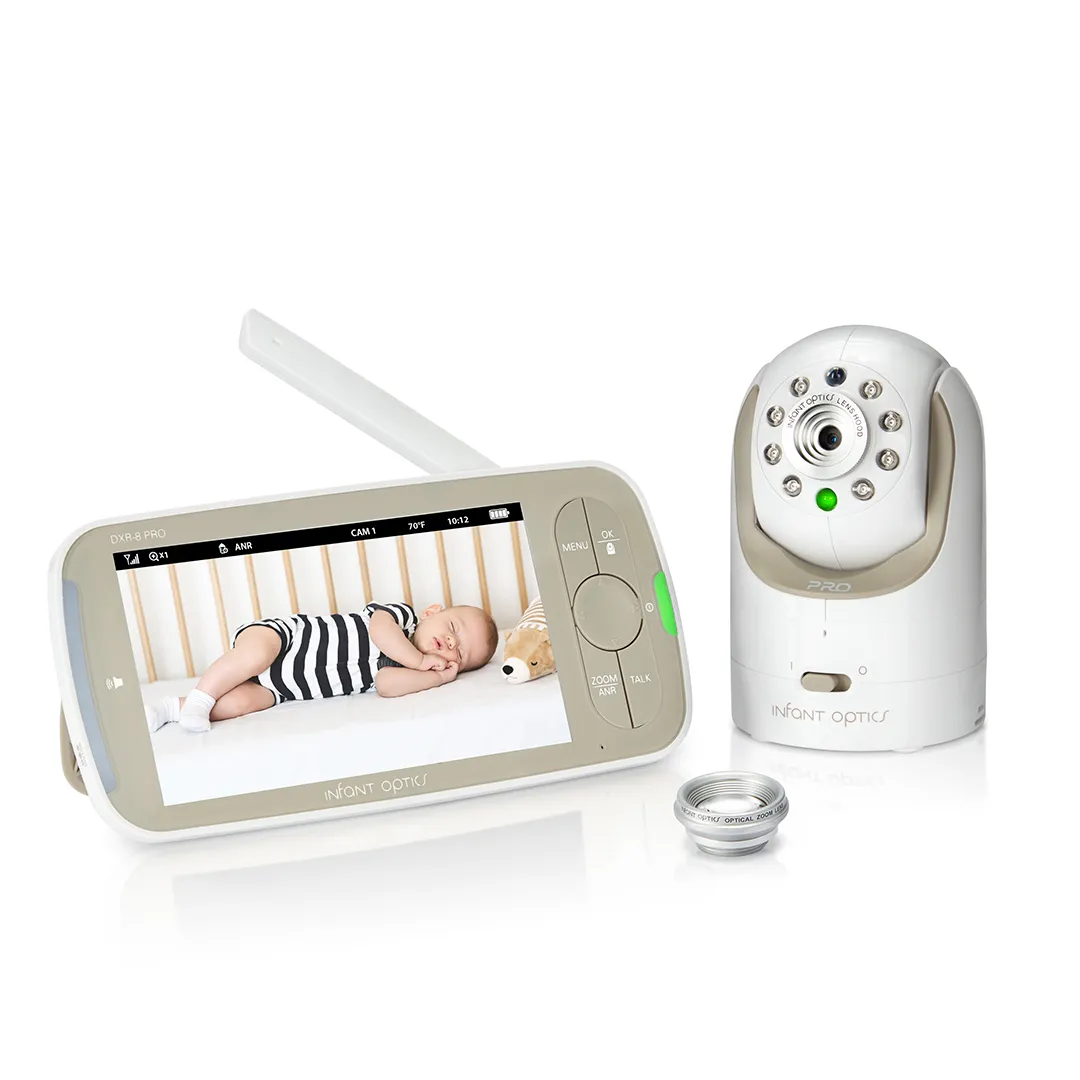 Infant Optics DXR-8 PRO kit on a white background: the white 5-inch monitor with raised antenna and a beige control panel beside the white pan-tilt camera with eight infrared LEDs, a spare optical zoom lens at the lower right, the monitor screen showing the camera's view of a sleeping baby