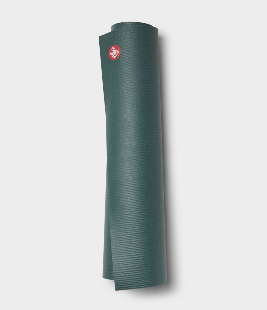 Manduka PRO yoga mat in black, rolled with the top surface facing out