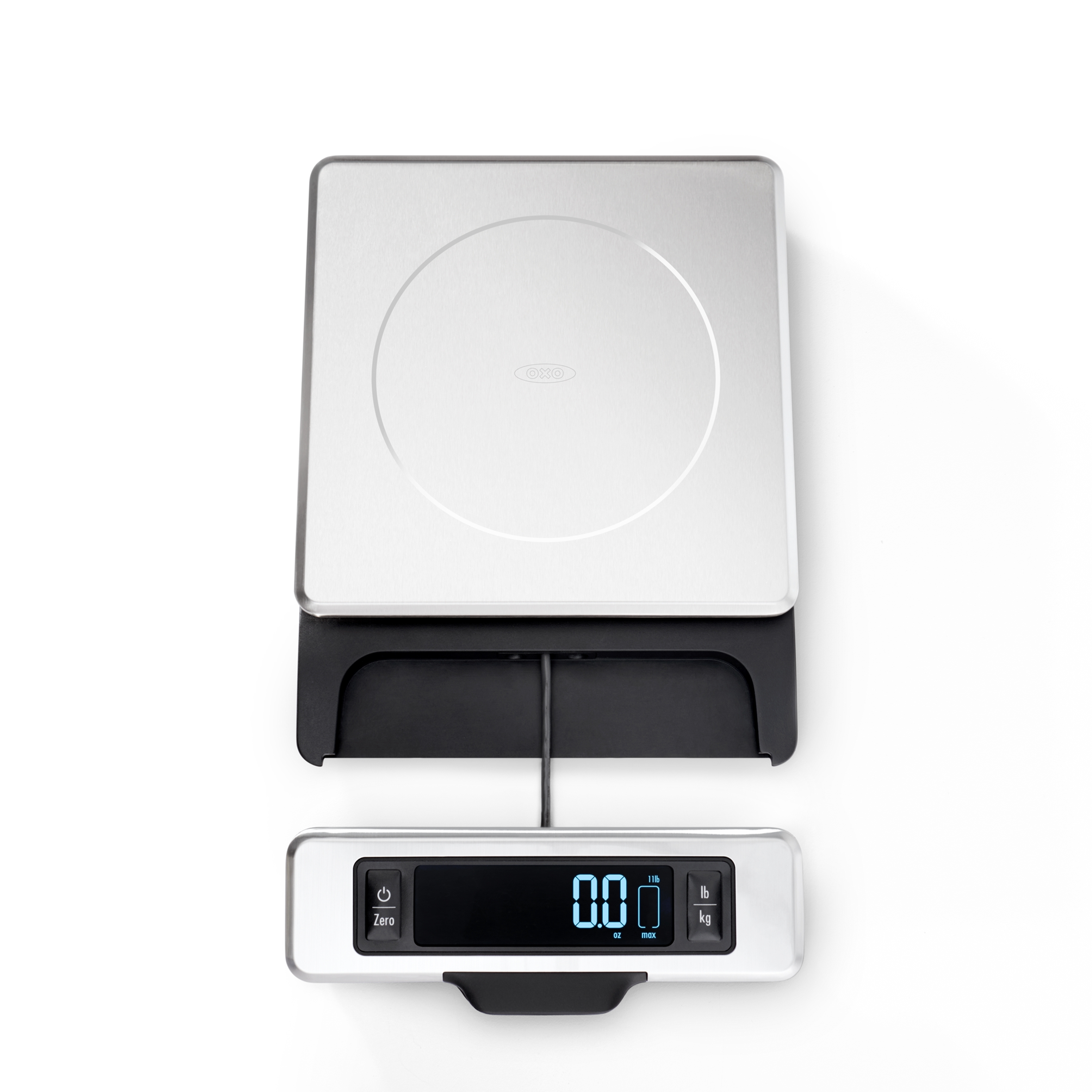 OXO 11 lb food scale seen from above on a plain white background: brushed stainless platform with the OXO logo, black base, and the pull-out display unit extended in front on a dark strap, its blue LCD reading 0.0 oz with an 11 lb max indicator and the lb/kg button beside it