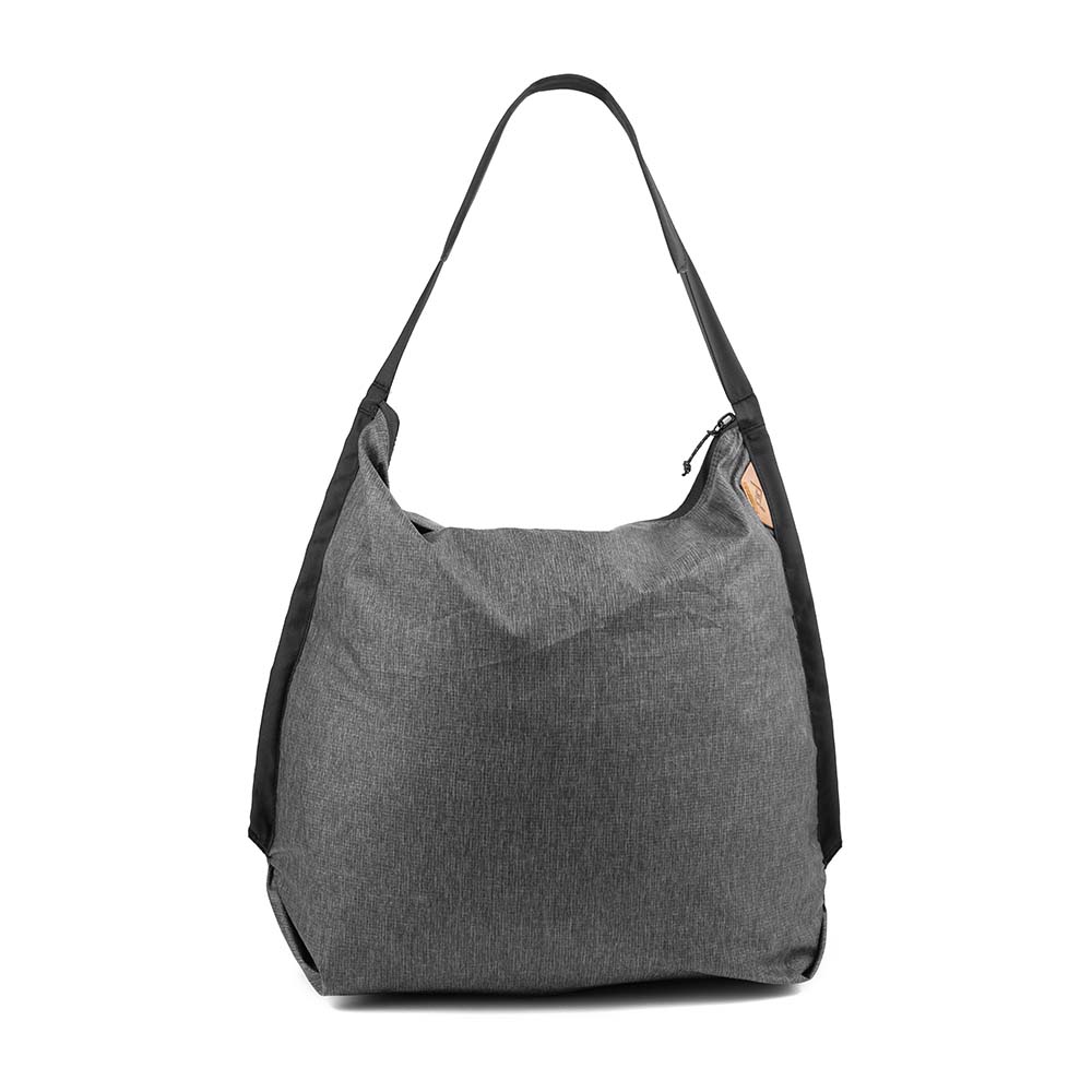 Charcoal Peak Design Packable Tote standing open, showing the zip closure and single padded strap