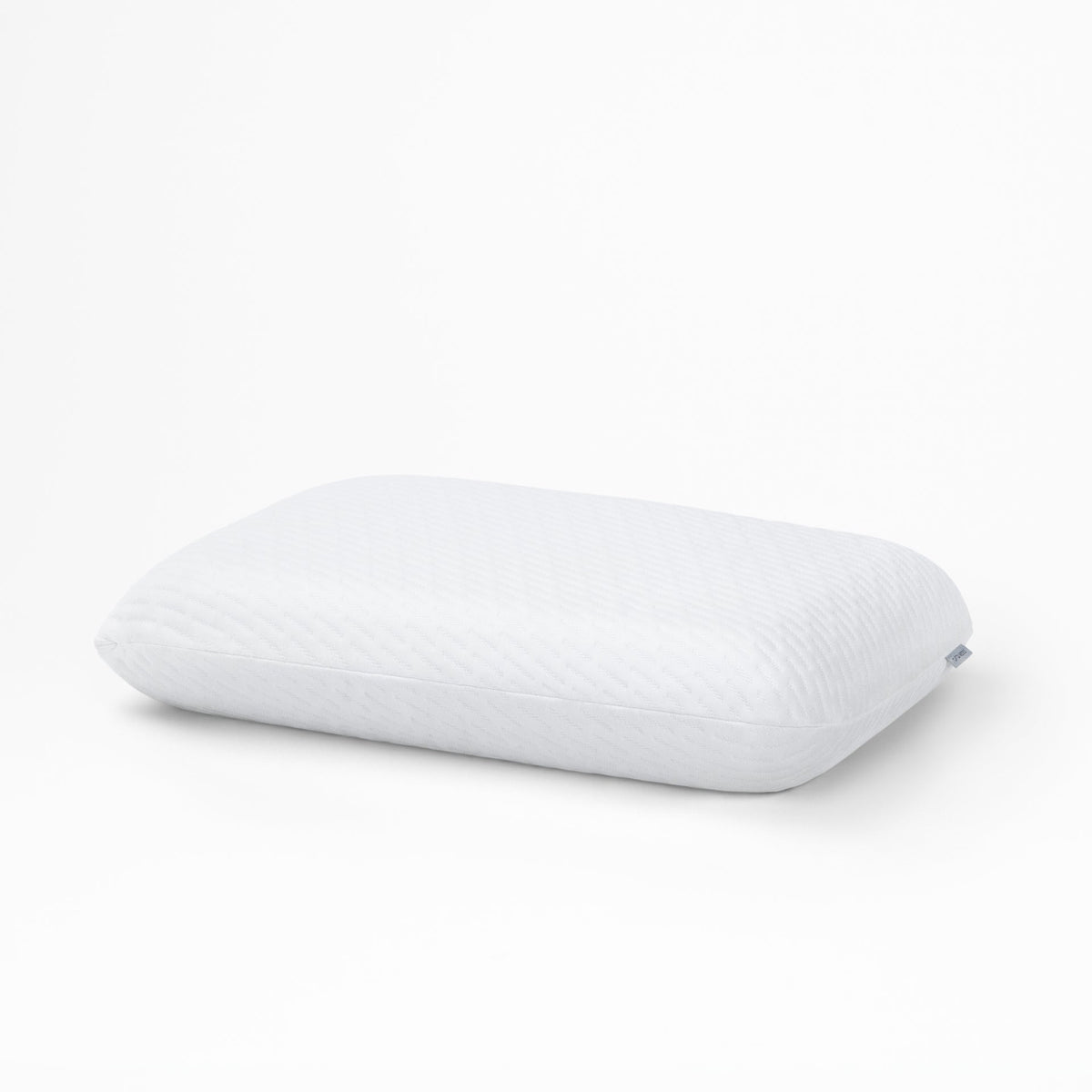 White Tuft & Needle Original Foam Pillow with a fabric brand tag on the edge, on a plain background