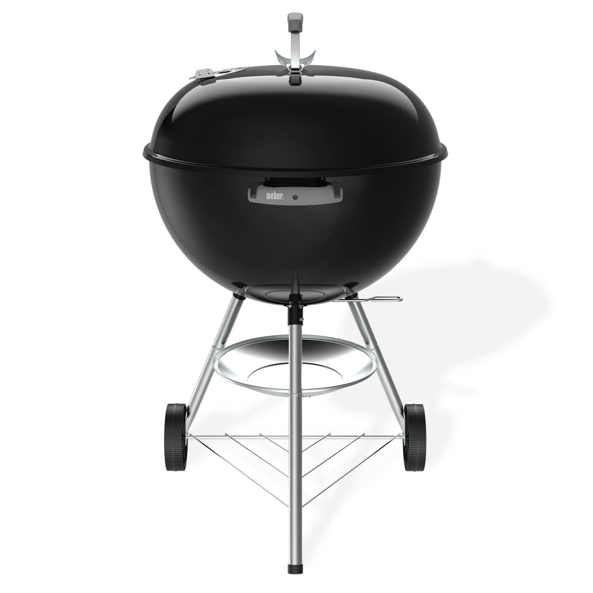 Black Weber Original Kettle 22-inch charcoal grill on a white background, lid closed, with a gray Weber-logo handle on the bowl, the thin One-Touch lever sticking out under the bowl on the right, two black wheels and a round ash catcher held between the legs